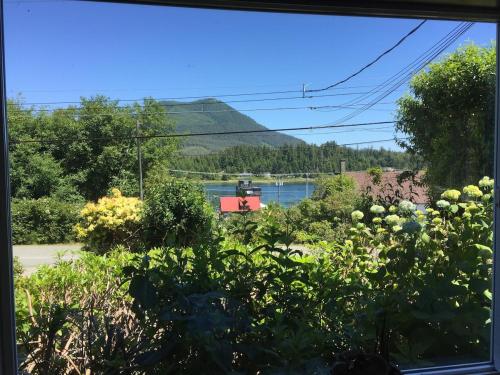 a window view of a garden with a view of a lake at Sea Breeze Suite - Centrally Located in Ucluelet in Ucluelet