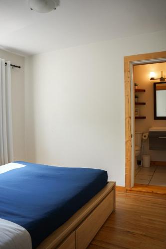 a bedroom with a bed and a bathroom with a television at Sea Breeze Suite - Centrally Located in Ucluelet in Ucluelet