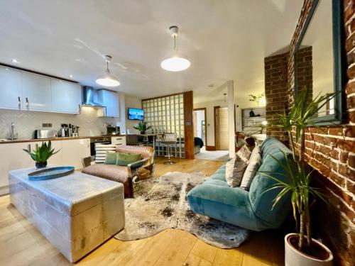 a living room with a green couch and a brick wall at By The Beach Large Central Stylish Studio for 4 Guests in Brighton & Hove