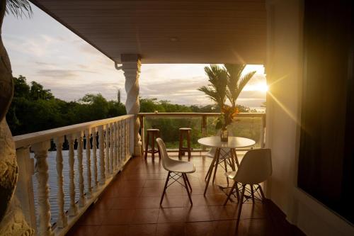 a balcony with a table and chairs on a porch at Puravidovo, ocean view, hill side in Golfito