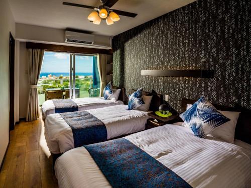 una camera d'albergo con tre letti e una finestra di Zoe Resort The Sunset Village Okinawa Chatan a Chatan
