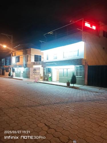 a gas station at night with a red light at Hotel Guajacum Riobamba in Riobamba