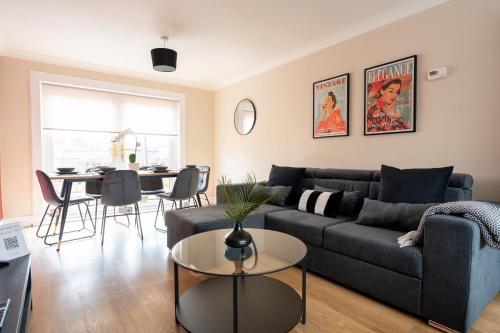 a living room with a couch and a table at Beauly Court Suites in Grangemouth