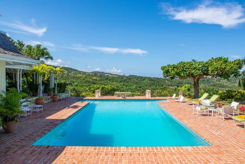 a large swimming pool with chairs at Windsong Villa in Hopewell