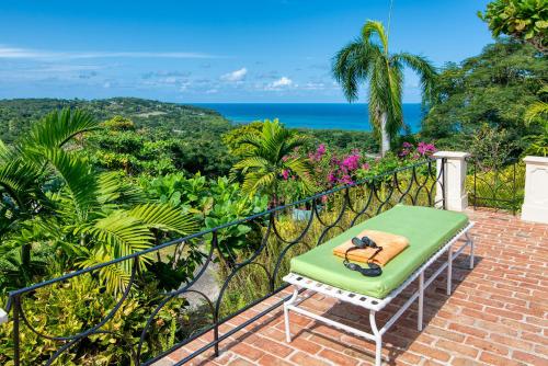 a green chair on a balcony with a view of the ocean at Windsong Villa in Hopewell