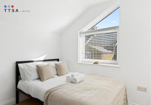 a white bedroom with a bed and a window at TTSA - Studio - Norwood Junction - B4 in Norwood