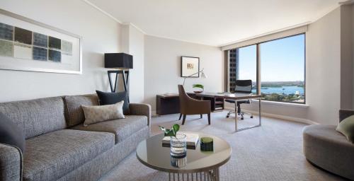 a living room with a couch and a table at Four Seasons Hotel Sydney in Sydney