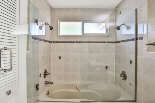 a white bathroom with a tub and a window at Renovated 3BR Dog Friendly Pond View WD in Whitfield
