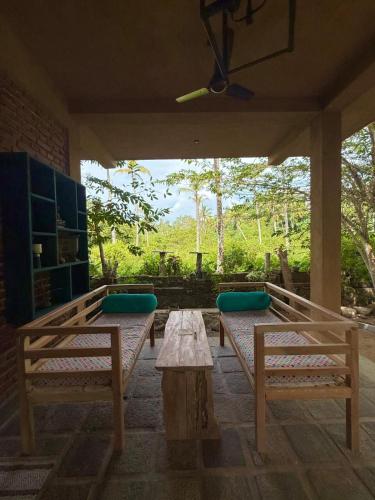 a porch with benches and a table with a view at villa ovita in Talpe