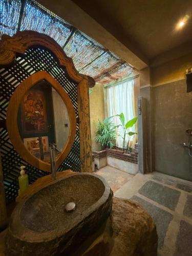 a bathroom with a stone sink and a mirror at villa ovita in Talpe