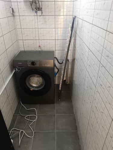 a small bathroom with a washing machine in a stall at T3 Moderne et Cosy, Riviera 3, 10min Abidjan mall in Abidjan