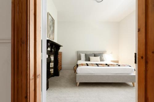 a bedroom with a large bed with white sheets at Charming 3-Bedroom Home with Sunroom & Parking in Kings Park