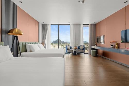 a hotel room with two beds and a tv at Lavender Hotel Vân Đồn in Tài Xá