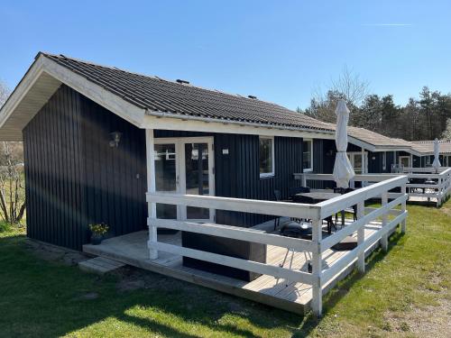 a blue house with a porch and a deck at Feriepark Langeland Ristinge (Feriepark Langeland) in Humble