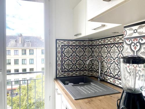 une cuisine avec un motif noir et blanc sur le mur dans l'établissement NaonedLoft au Coeur de la Ville, à Nantes