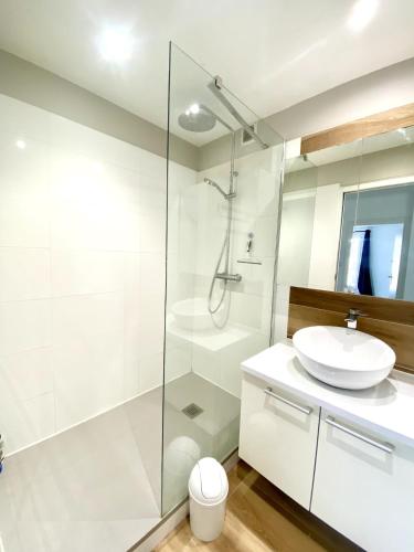 une salle de bain blanche avec un lavabo et une douche dans l'établissement NaonedLoft au Coeur de la Ville, à Nantes