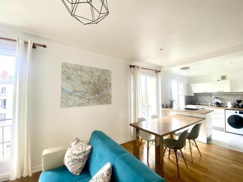 un salon avec un canapé bleu et une table dans l'établissement NaonedLoft au Coeur de la Ville, à Nantes