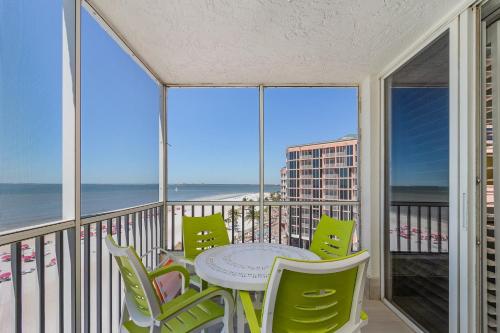 a balcony with a table and chairs and the ocean at Beach Villas 706 Top-Floor Condo with Gulf Views, Pool condo in Fort Myers Beach