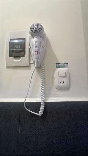 a hair dryer and a phone on a wall at Lima Airport Tampu in Lima