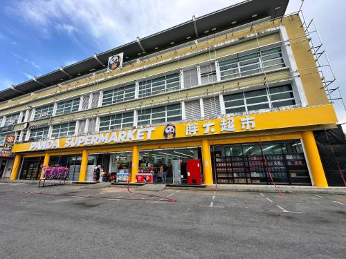 Un gran edificio amarillo con un cartel en él. en Natol Hotel, en Kuching