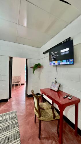 a red table and a chair in a room at Apartamento Mirador de La ciudad in Jarabacoa