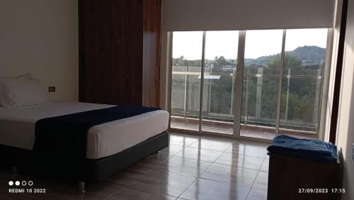 a bedroom with a bed and a large window at Villa Maru in El Peñol