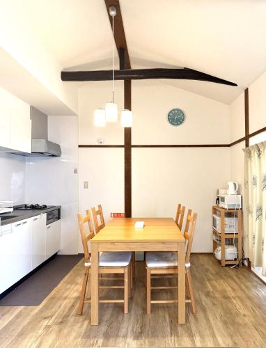 a kitchen and dining room with a wooden table and chairs at MIC’s house haneda2 in Tokyo