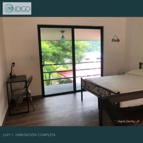 a bedroom with a bed and a door to a balcony at Hermoso apartamento tipo loft in Nicoya