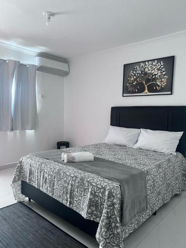 a bedroom with a bed with a black and white blanket at Salt Lake Suítes in Arraial do Cabo