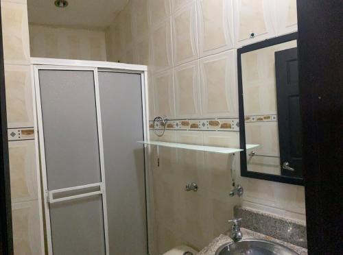 a bathroom with a shower and a sink and a mirror at Casa amoblada in Apartadó
