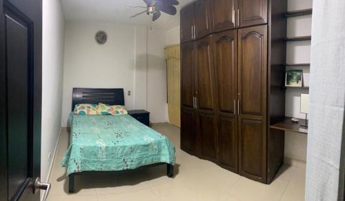 a bedroom with a bed and a large wooden cabinet at Casa amoblada in Apartadó