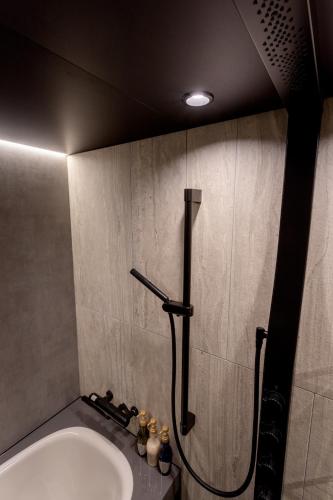 a bathroom with a shower and a sink at Hotel Sundays Amami in Amami