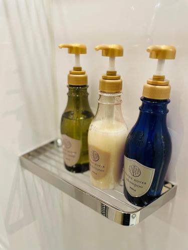 three bottles of milk are sitting on a shelf in a refrigerator at Hotel Sundays Amami in Amami