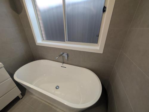 a bathroom with a toilet and a sink and a mirror at Strawberry Lodge in Newcastle