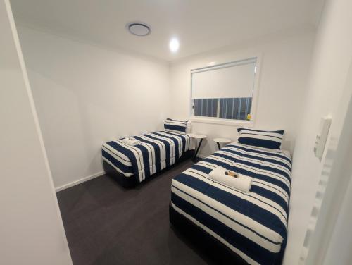 a room with two beds and a mirror at Strawberry Lodge in Newcastle