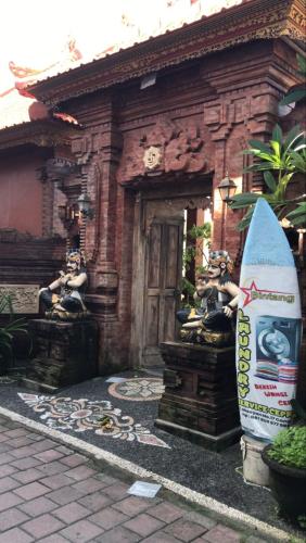 a house with a surfboard in front of a building at Palm&Ocean Canggu in Canggu