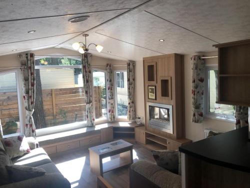 a living room with a couch and some windows at Chalet near Antwerp with Nature Trails in Beulk