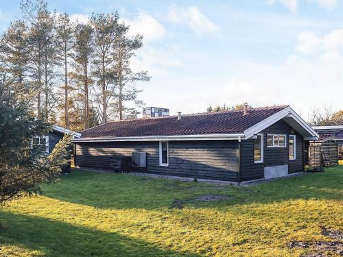 a wooden house with a yard in front of it at 4 star holiday home in Hals in Hals