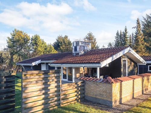 a house with a wooden fence in front of it at 4 star holiday home in Hals in Hals