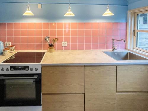 a kitchen with pink tiles on the wall and a sink at 6 person holiday home in Marstal in Marstal