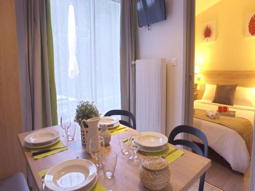 a dining room table with plates and wine glasses on it at Cottage in Semur-en-Auxois in Forest Retreat in Semur-en-Auxois