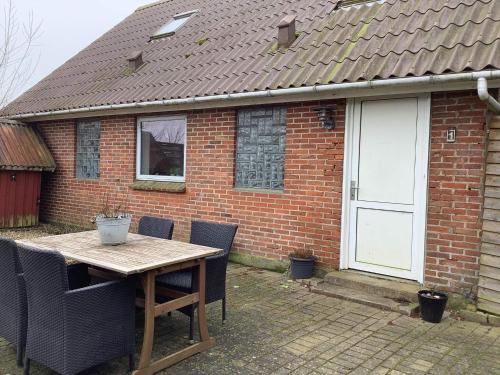 a table and chairs in front of a brick house at 5 person holiday home in Snedsted in Snedsted