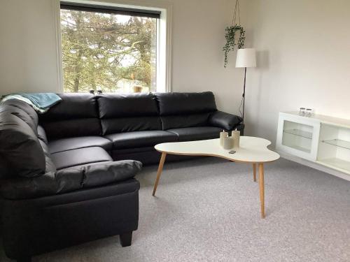 a living room with a black couch and a table at 5 person holiday home in Snedsted in Snedsted
