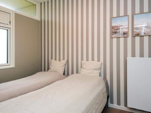 two beds in a room with striped walls at 4 star holiday home in Fanø in Fanø