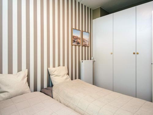a bedroom with two beds and striped walls at 4 star holiday home in Fanø in Fanø