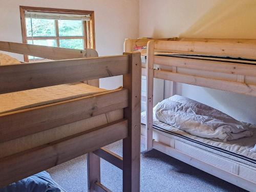 two bunk beds in a room with a window at 6 person holiday home in Storvorde in Storvorde