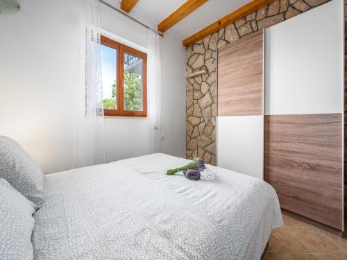 a bedroom with a white bed and a window at Apartment in Drenje with Stunning Sea View in Drenje