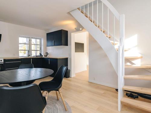a kitchen and dining room with a table and stairs at 5 star holiday home in Liseleje in Liseleje