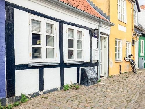 a white and black building with windows on a street at 4 star holiday home in Aalborg in Aalborg