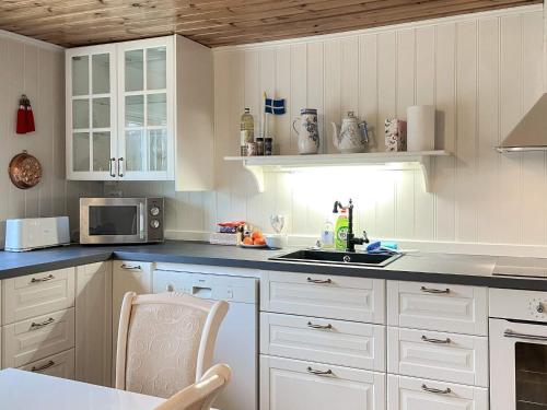 a kitchen with white cabinets and a sink at 10 person holiday home in VITTSJÖ in Vittsjö